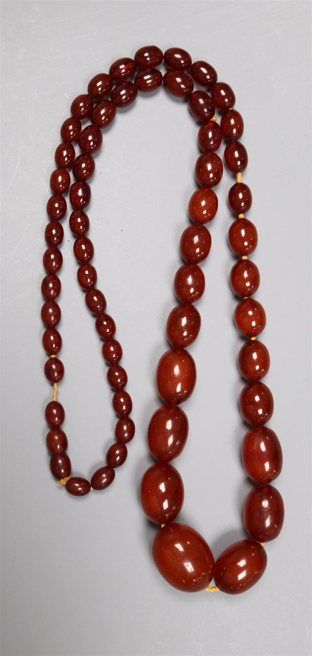 A single strand graduated oval simulated amber bead necklace, 80cm, gross 70 grams.